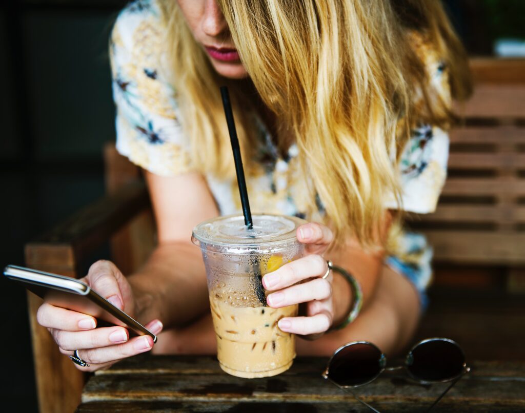 Social media manager looks at smartphone, possibly various social media platforms, looking for social media skills for a resume, while drinking iced coffee  https://upload.wikimedia.org/wikipedia/commons/a/ac/Adolescent_smartphone.jpg
